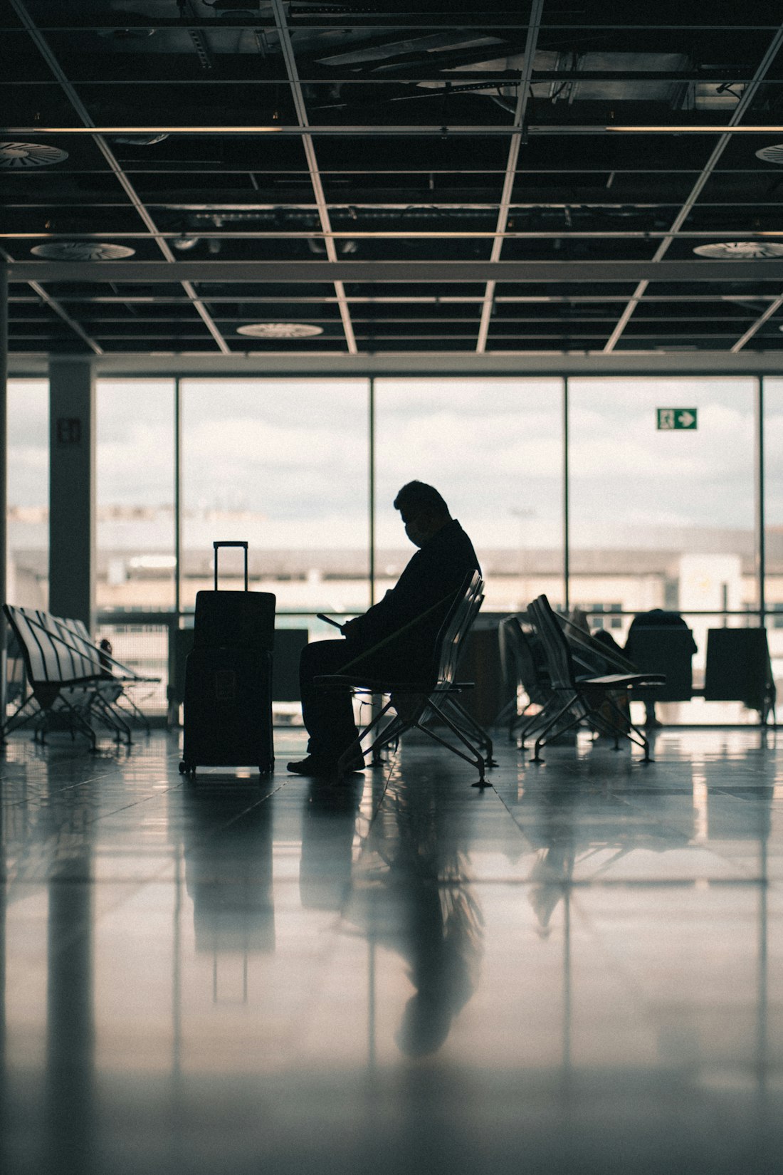 A business traveller working on a phone at an airport gate